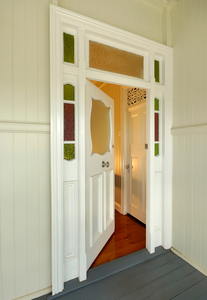 Door to old colonial style wooden home, slightly open with warm