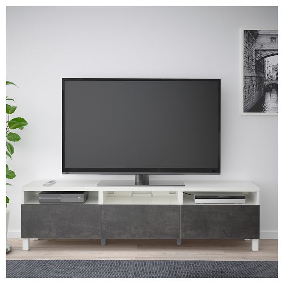 Uncluttered Modern TV Unit with Potted Plant and Framed Artwork